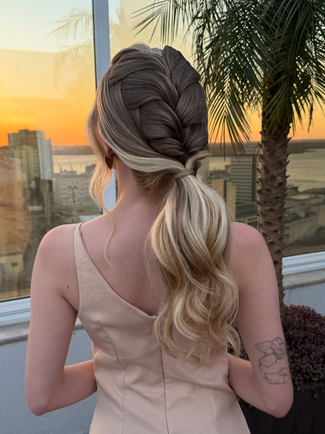 French braid into low ponytail with curled ends.
