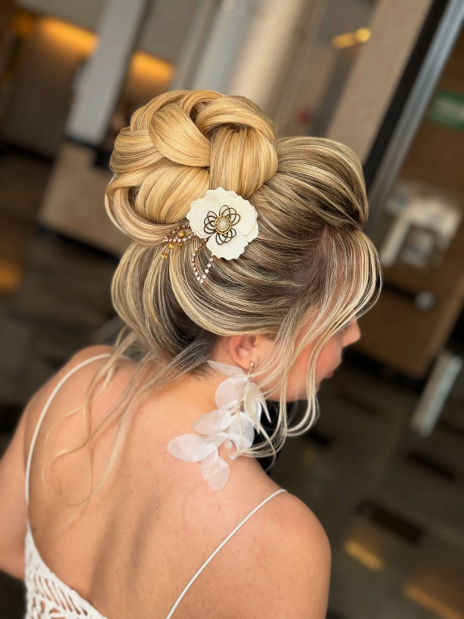 Sculptural bridal updo with white flower comb.
