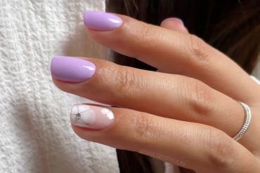 Glossy lavender short nails with white flower and crystal accent. Minimalist Blue Nails with Pearl Bow Tips