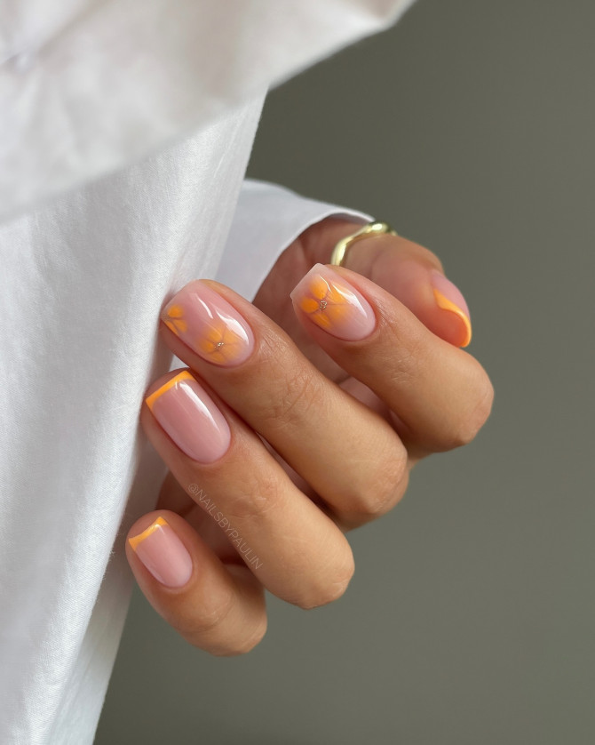 Orange French tip nails with translucent flower nail art on short nails