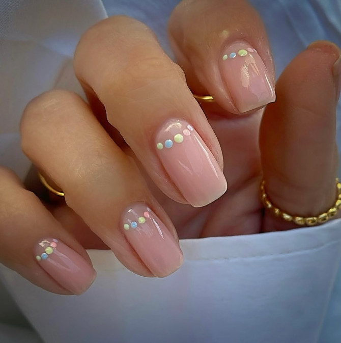 minimalist nude nails with curved pastel dot pattern
