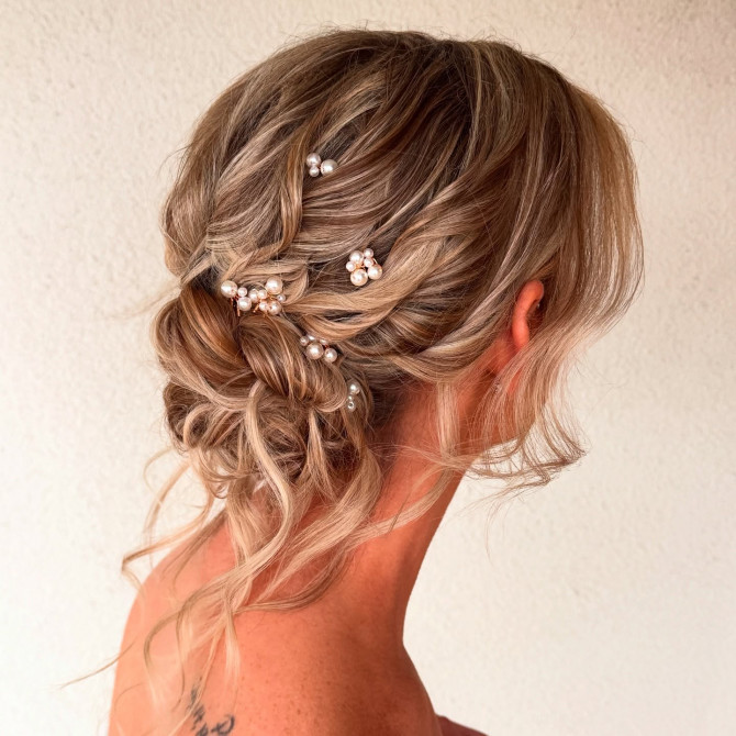 Romantic twisted bridal updo hairstyle with pearl accessories
