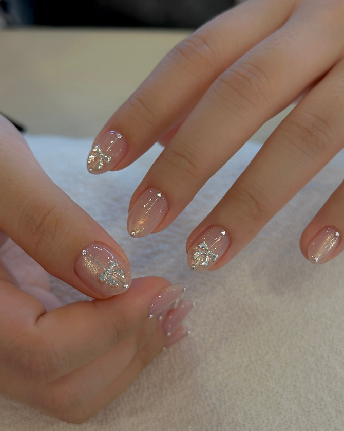 bridal nails with silver 3D bows and shimmer nude base