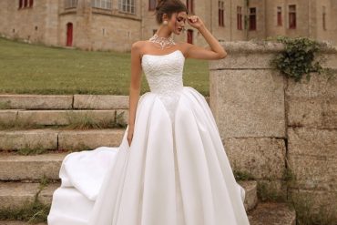 Strapless regal ballgown with dramatic full skirt photographed at a château — international bridal gowns fairytale.
