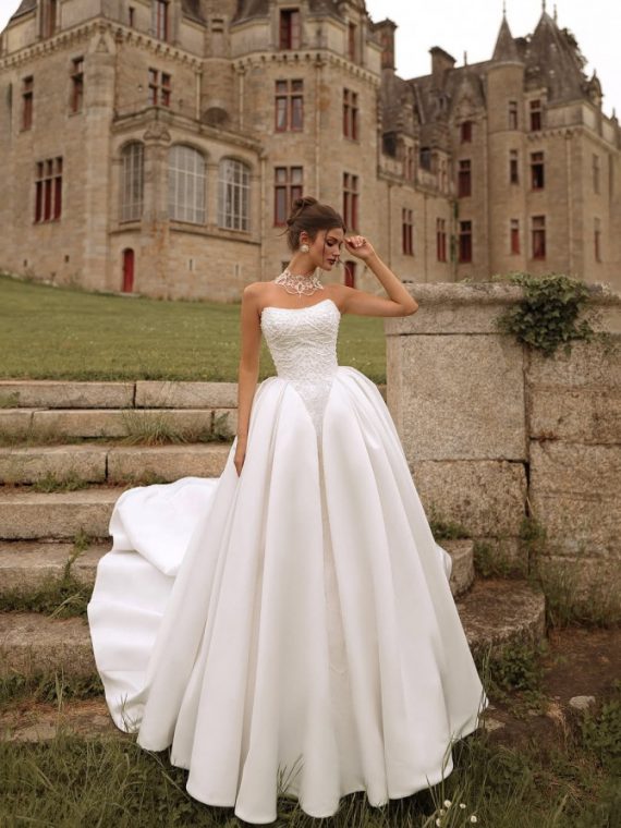 Strapless regal ballgown with dramatic full skirt photographed at a château — international bridal gowns fairytale.
