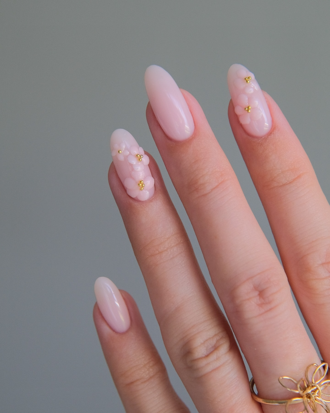 3D floral manicure with tiny gold centers on a blush base