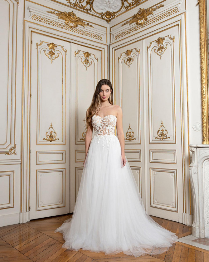 Strapless lace illusion bodice with floral appliqués and a tulle A-line skirt; romantic bridal look. “Strapless lace illusion A-line bridal gowns look with floral appliqués and light tulle skirt.”
