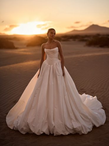 Dramatic draped taffeta ballgown at sunset; statement bridal gowns moment.