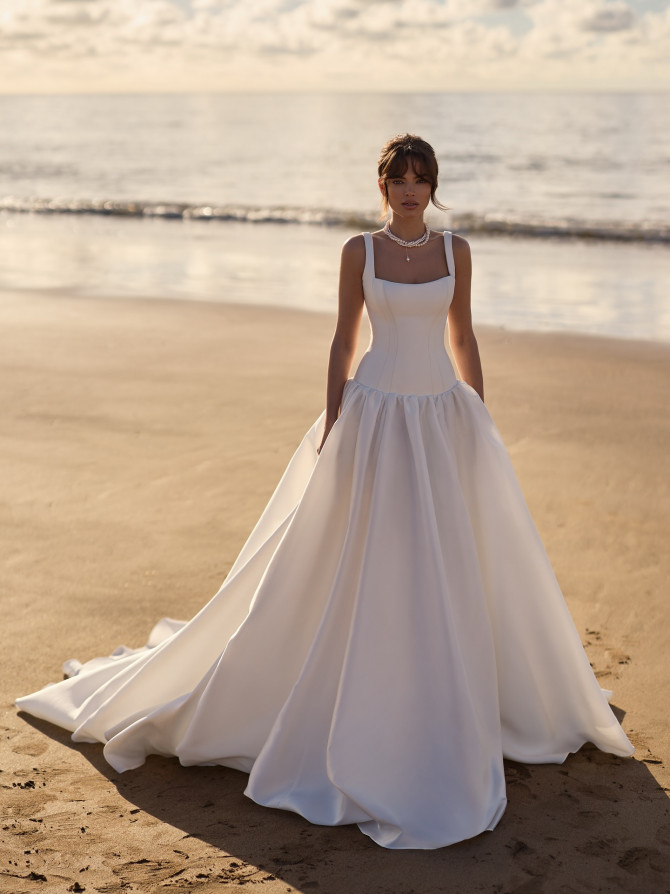 Square-neck satin ballgown with slim straps on the beach; polished bridal gowns style.