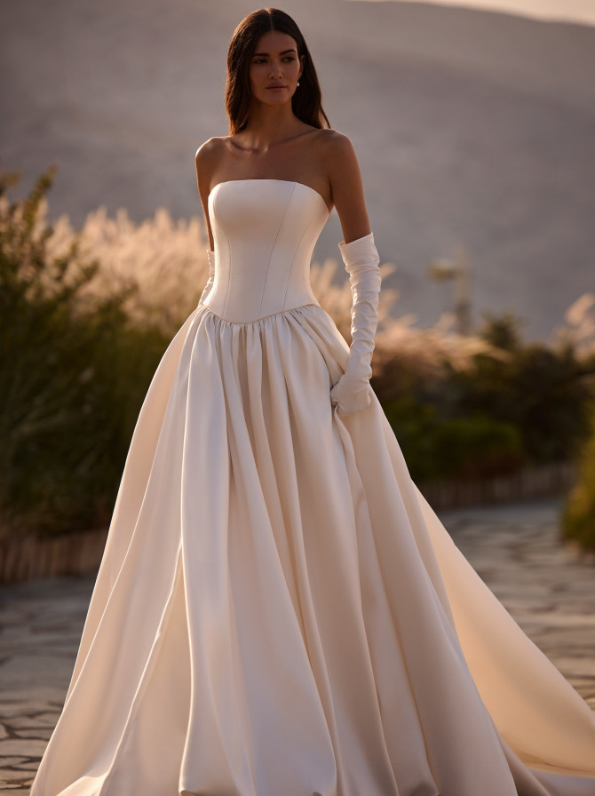 Minimal strapless satin ballgown styled with opera gloves; timeless bridal gowns look.