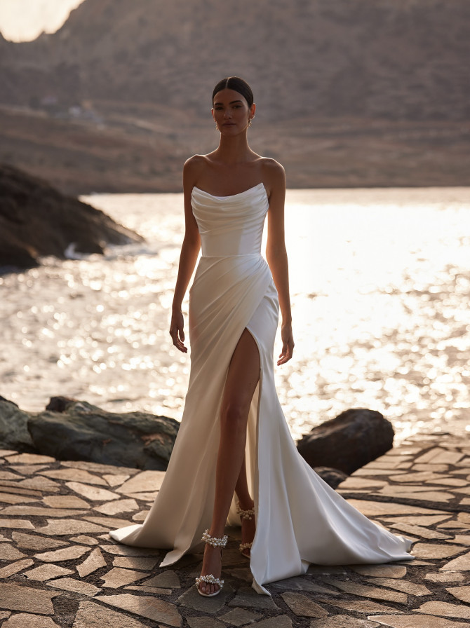 Satin cowl-neck sheath with wrap front slit; modern bridal gowns look at golden hour.
