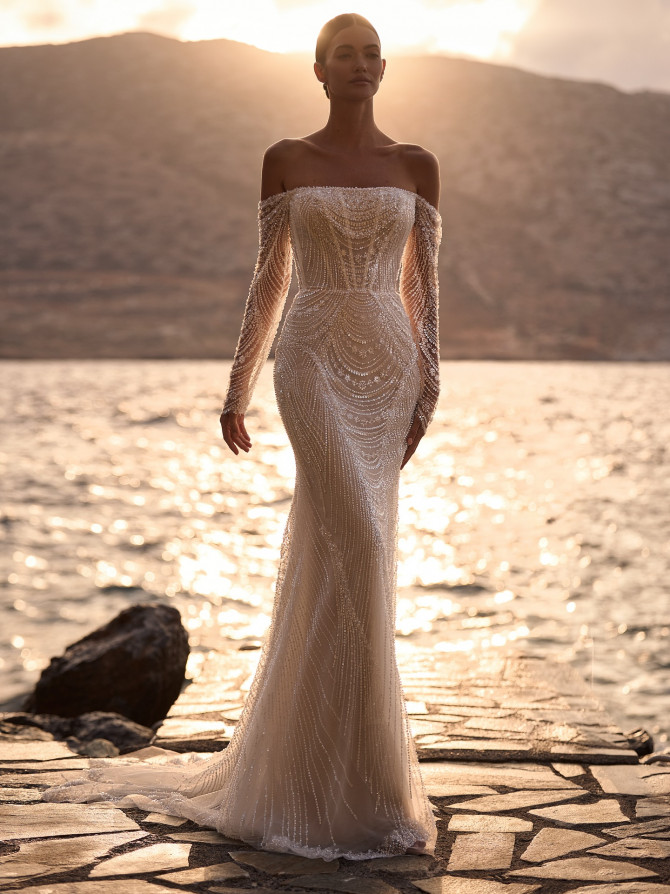 Off-shoulder beaded sheath catching sunset glow; refined bridal gowns silhouette