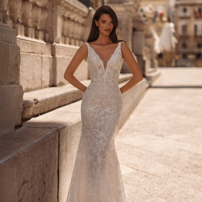 Deep-V lace sheath with scalloped straps and chapel train — international bridal gowns classic. 