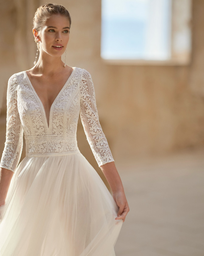 Crochet lace bodice with three-quarter sleeves and tulle skirt — international bridal gowns. 