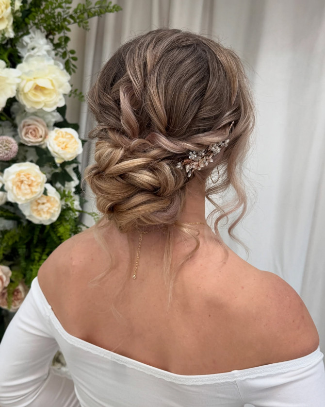 Twisted low bridal bun hairstyle with floral hair vine accessory